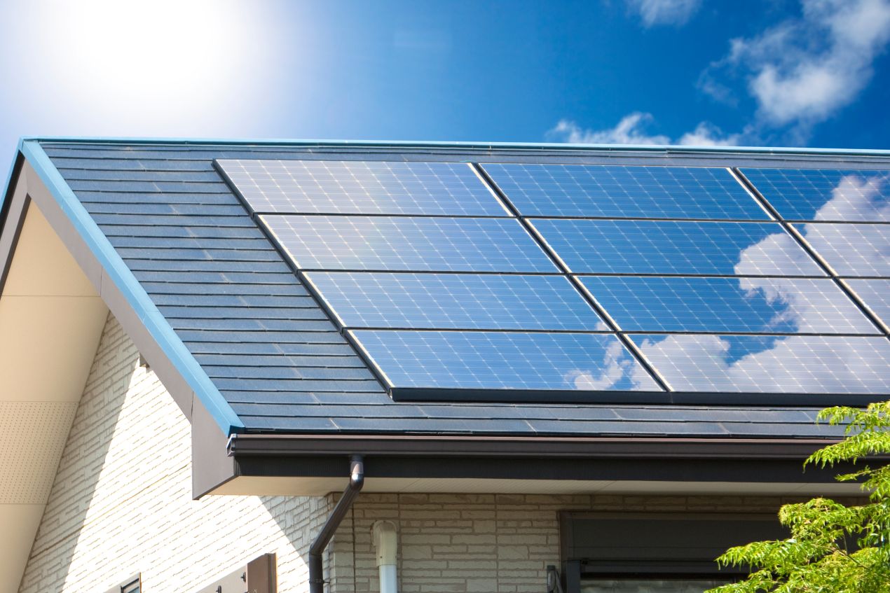 Solaranlage auf modernem Hausdach mit blauen Hochleistungsmodulen, perfektes Beispiel für Qualität im Solar Grosshandel